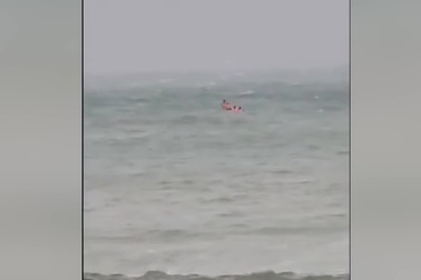 Ba người đàn ông trên thuyền thúng không thể vào bờ vì gió to, sóng lớn