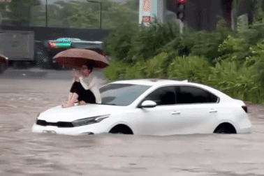 Hà Nội ngập mọi ngả: Người phụ nữ gây "sốt" khi ngồi trên ô tô gọi cứu hộ