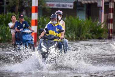 Triều cường dâng cao, người dân TPHCM "lội nước" đi chơi Tết