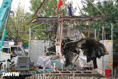 Cảnh cần cẩu nhấc bổng xác pháo đài bay B-52 dưới đáy hồ lên bờ ở Hà Nội