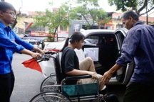 Cha đưa con gái ngồi xe lăn đến làm thủ tục thi THPT quốc gia