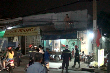 Người đàn ông cởi quần áo, trèo lên nóc nhà cố thủ