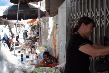 Mẹ cầu thủ Hoàng Thị Loan vừa bán hàng ở chợ, vừa theo dõi con đá World Cup