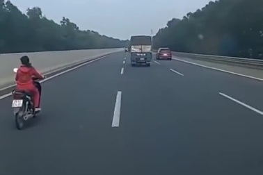 Người phụ nữ đầu trần chạy xe máy trên cao tốc
