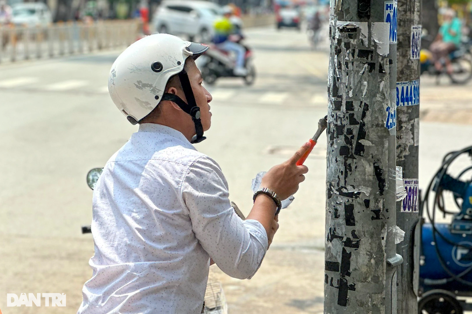 Dán quảng cáo lên cột điện TPHCM, người vi phạm bị bắt đi cạo bỏ - 1