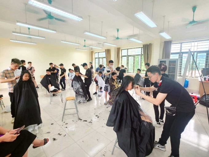Các thành viên Câu lạc bộ Người điếc Quảng Ninh tình nguyện cắt tóc miễn phí cho 30 em học sinh của trường Tiểu học và THCS Vũ Oai (TP Hạ Long).