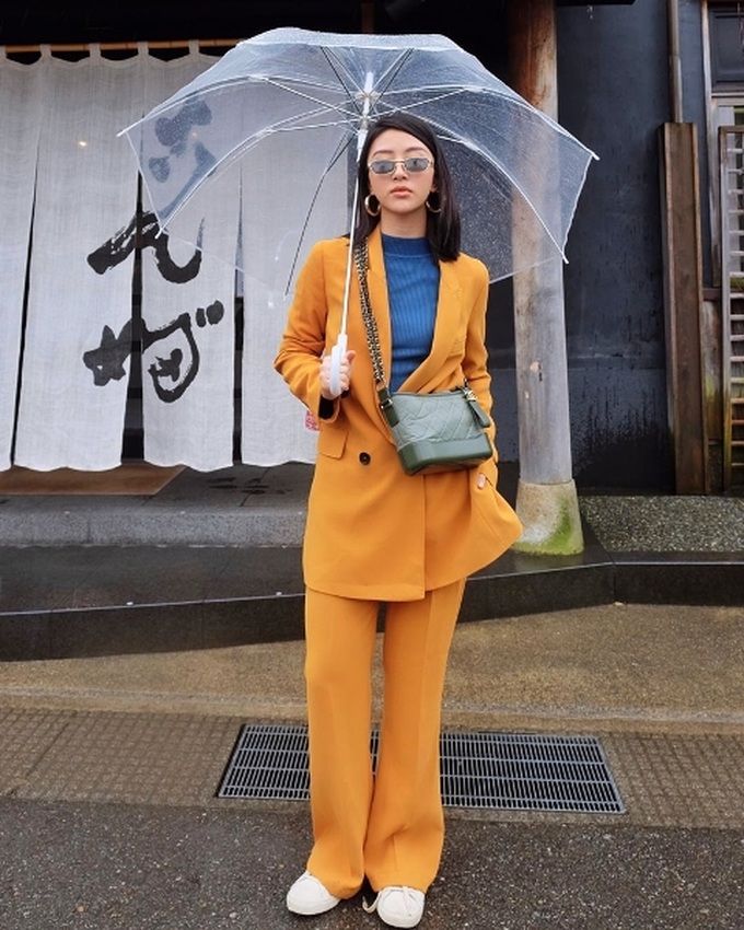 Quỳnh Anh Shyn “chơi trội” với bộ suit mang gam vàng mù tạt, kết hợp áo thun tông màu xanh hoàng gia và điểm xuyết bằng túi Gabrielle Chanel đắt giá.