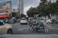 Người đàn ông chở thanh kim loại đi như Tôn Ngộ Không vác gậy qua giao lộ