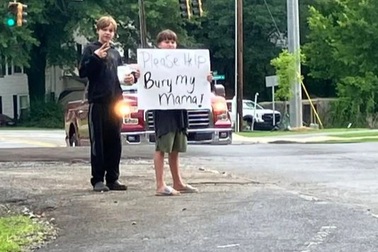 Bé trai cầm bảng đứng bên đường mong được giúp đỡ chôn cất mẹ gây xúc động