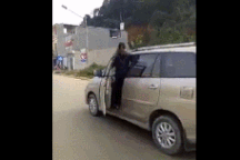 Khó hiểu người phụ nữ vừa lái xe, vừa mở cửa nhoài người ra nói chuyện điện thoại