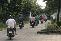 Xe cộ tấp nập chạy trên vỉa hè gần trụ sở cảnh sát giao thông