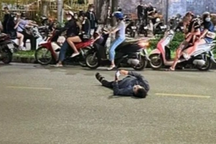 Người đàn ông nằm giữa đường xem điện thoại đang phải điều trị tâm lý