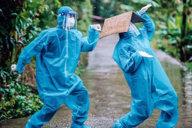 Tan chảy hình ảnh nhảy múa dưới mưa của đôi tình nguyện viên chống dịch