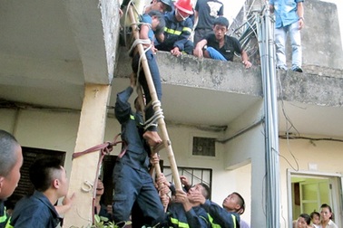 Hà Nội: Giải cứu thiếu nữ ngồi trên mái nhà, thả tiền xuống đất