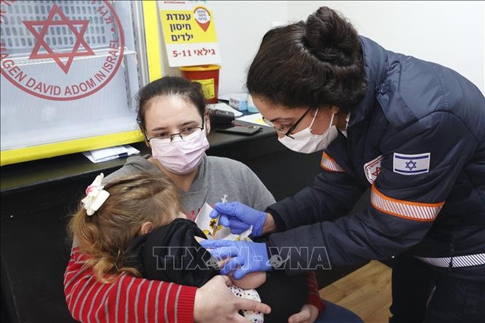Nhân viên y tế tiêm vaccine ngừa COVID-19 cho trẻ em tại Tel Aviv, Israel. Ảnh: AFP/TTXVN
