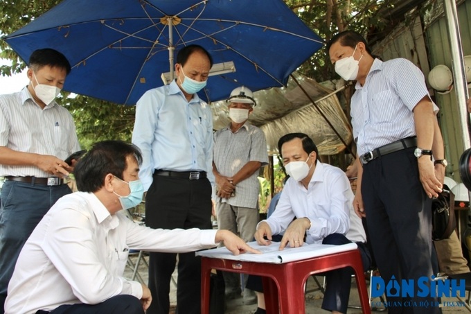 Bộ trưởng Đào Ngọc Dung kiểm tra bản vẽ thiết kế và nghe nhà thầu, đơn vị thi công báo cáo.