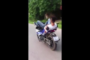 “Diễn xiếc” nằm ngửa lái xe máy bằng chân trên đường