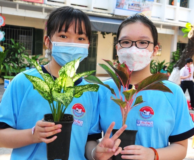 Hai học sinh trường Tân Lập 2 thích thú với cây xanh vừa đổi được.