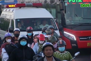 Trẻ em ngủ gục trên xe máy theo cha mẹ rời TPHCM về quê nghỉ lễ