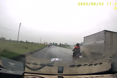 Xe tải vượt ẩu làm bắn nước lên người đi xe máy