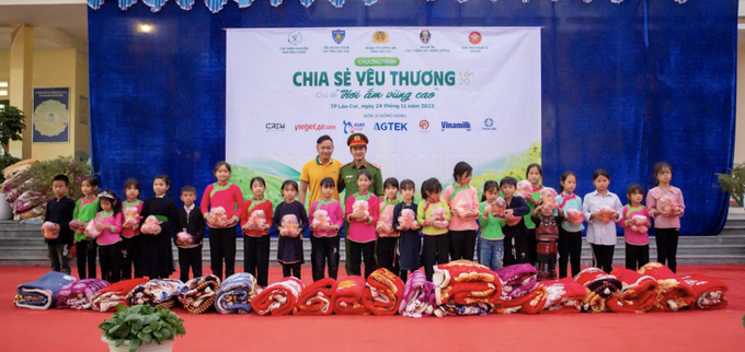 Trung tá Vũ Thế Anh, Phó tiểu đoàn trưởng, Tiểu đoàn Cảnh sát cơ động, Phòng Cảnh sát cơ động Công an tỉnh Lào Cai cùng nhà hảo tâm trao tặng những phần quà thiết thực, ý nghĩa đến các em nhỏ.