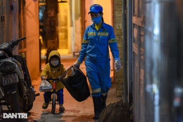 Chạnh lòng hình ảnh cậu bé 2 tuổi theo mẹ đi dọn rác giữa đêm đông Hà Nội