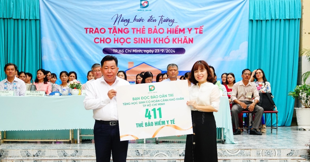 Nhà báo Phạm Tâm trao tận tay thẻ BHYT của bạn đọc tới các em học sinh có hoàn cảnh khó khăn (Ảnh: Nguyễn Vy).