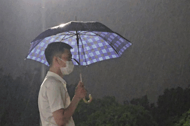 Người dân lặng lẽ đội mưa chứng kiến lễ hạ cờ tại Quảng trường Ba Đình