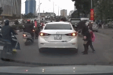 Ngán ngẩm nữ tài xế dừng xe giữa đường đông để đón con