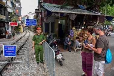 Du khách xếp hàng chụp ảnh phố cà phê đường tàu... qua rào chắn