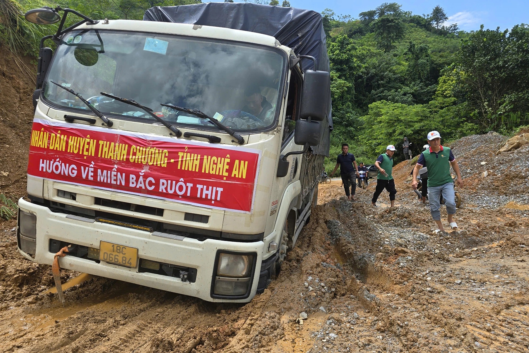 Xe cứu trợ chở hàng hóa của người dân huyện Thanh Chương (Nghệ An) sa lầy trên đường tiếp cận khu vực bị chia cắt (Ảnh: Tư Hoàng).