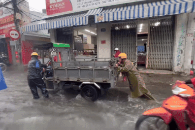 CSGT giúp dân đẩy hàng chục xe bị chết máy qua rốn ngập chợ Thủ Đức