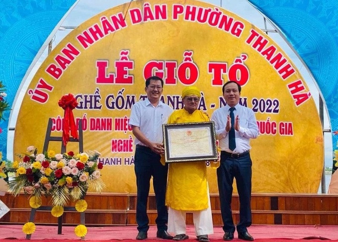 Ông Nguyễn Văn Lanh, Phó chủ tịch UBND TP Hội An (trái), trao bằng chứng nhận danh hiệu Di sản văn hóa phi vật thể cấp quốc gia cho nghệ nhân làng gốm Thanh Hà. (Ảnh: Báo Công lý)