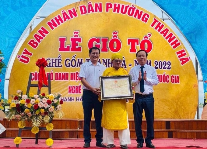 Ông Nguyễn Văn Lanh, Phó chủ tịch UBND TP Hội An (trái), trao bằng chứng nhận danh hiệu Di sản văn hóa phi vật thể cấp quốc gia cho nghệ nhân làng gốm Thanh Hà. (Ảnh: Báo Công lý) 