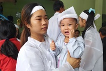 Bố mẹ bị lũ cuốn trôi, con gái 2 tuổi ngơ ngác đội khăn tang