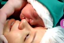 Ngọt ngào khoảnh khắc em bé vòng tay ôm má mẹ khi vừa mới lọt lòng