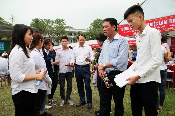 Phó Chủ tịch Trần Đức Quý và Phó Cục trưởng Cục việc làm Tào Bằng Huy trao đổi với người lao động tại hội chợ việc làm.
