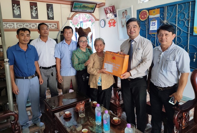 Giám đốc Sở LĐ-TB&XH Tạ Hồng Quang (thứ hai bên phải) thăm và tặng quà cho gia đình bà Đỗ Thị Thanh-Vợ liệt sĩ, ở xã Suối Tân, huyện Cam Lâm.