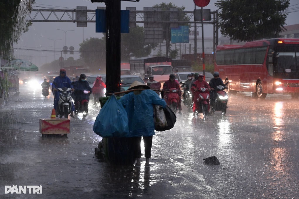 Người dân TPHCM chật vật di chuyển trong cơn mưa lớn vào sáng sớm - 1