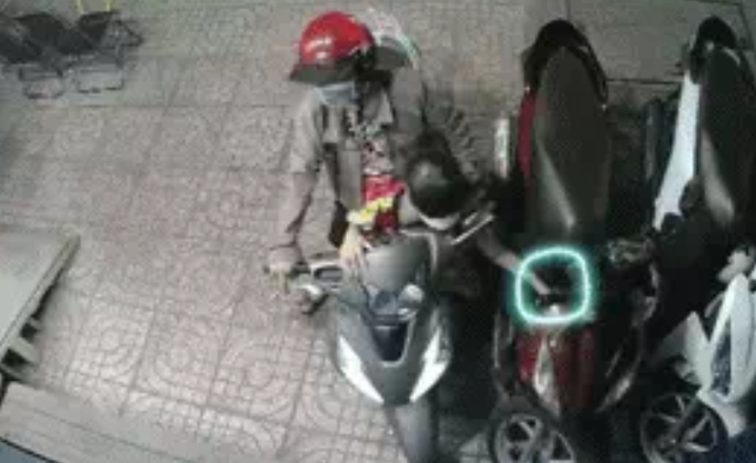 Cảnh người phụ nữ nghiêng hẳn xe máy sang một bên để đứa trẻ lấy trộm đồ dễ dàng hơn vào ngày 5/12/2021, được camera ghi lại.
