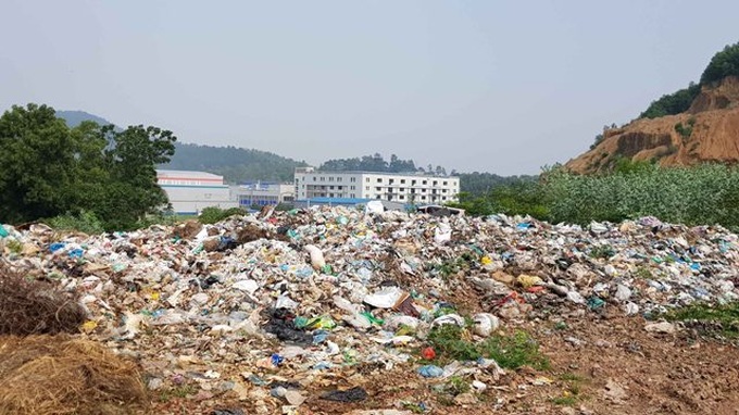 Bãi rác tạm Khai Quang cách khu dân cư, nhà máy sản xuất đúng một con đường - Ảnh: Nam Anh