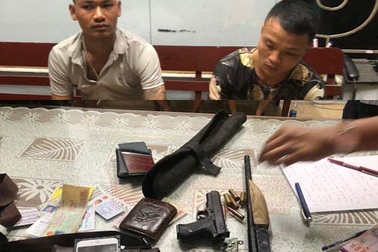 Hai thanh niên mang súng đã lên nòng nghênh ngang đi ngoài đường