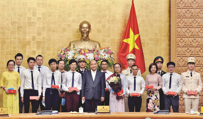 Chủ tịch nước Nguyễn Xuân Phúc (khi là Thủ tướng Chính phủ) tặng quà lưu niệm cho các gương mặt trẻ Việt Nam tiêu biểu năm 2020. Ảnh NVCC