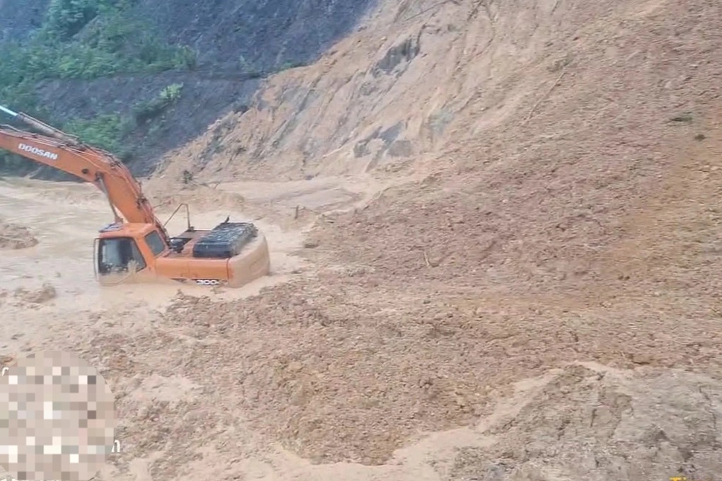 Bùn đất từ đồi bất ngờ đổ ập xuống vùi máy múc, tài xế thoát nạn - 1
