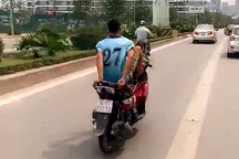 Nam thanh niên lái xe máy bằng chân trên làn đường buýt nhanh