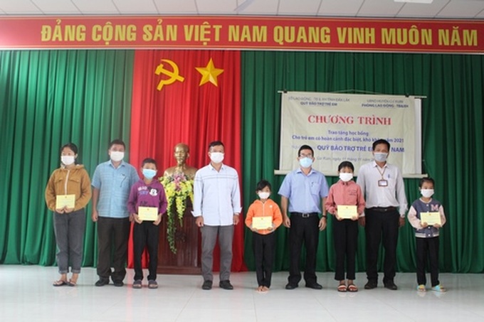 Lãnh đạo Quỹ Bảo trợ trẻ em tỉnh Đắk Lắk và chính quyền địa phương huyện Cư Kuin trao tặng học bổng cho trẻ em. Ảnh TTBTXH