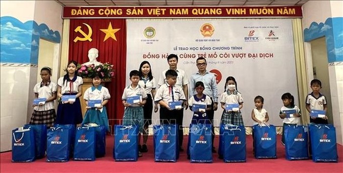 Trao quà cho các em mồ côi do COVID-19. Ảnh TTXVN