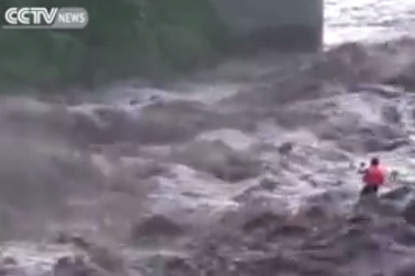 Người đàn ông đương đầu với dòng nước lũ cuồn cuộn