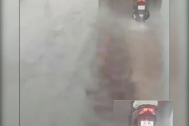 Người đàn ông liều lĩnh bám đuôi xe container để tránh mưa