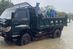 Phụ huynh dùng xe tải, thuyền thúng chở con về nhà giữa mưa lớn